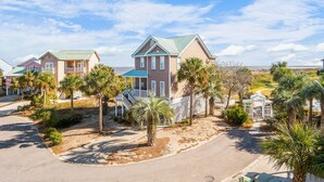 A residential area with houses, palm trees, and a clear sky. - Charming Ocean View Retreat- Steps to the Beach and Pool- Resort-Style Amenities (Saint Helena Island)