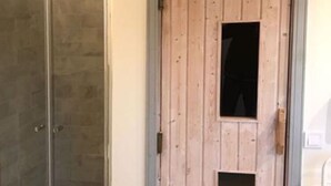 Une porte en bois avec une petite fenêtre, une porte vitrée sur la gauche et un mur uni.