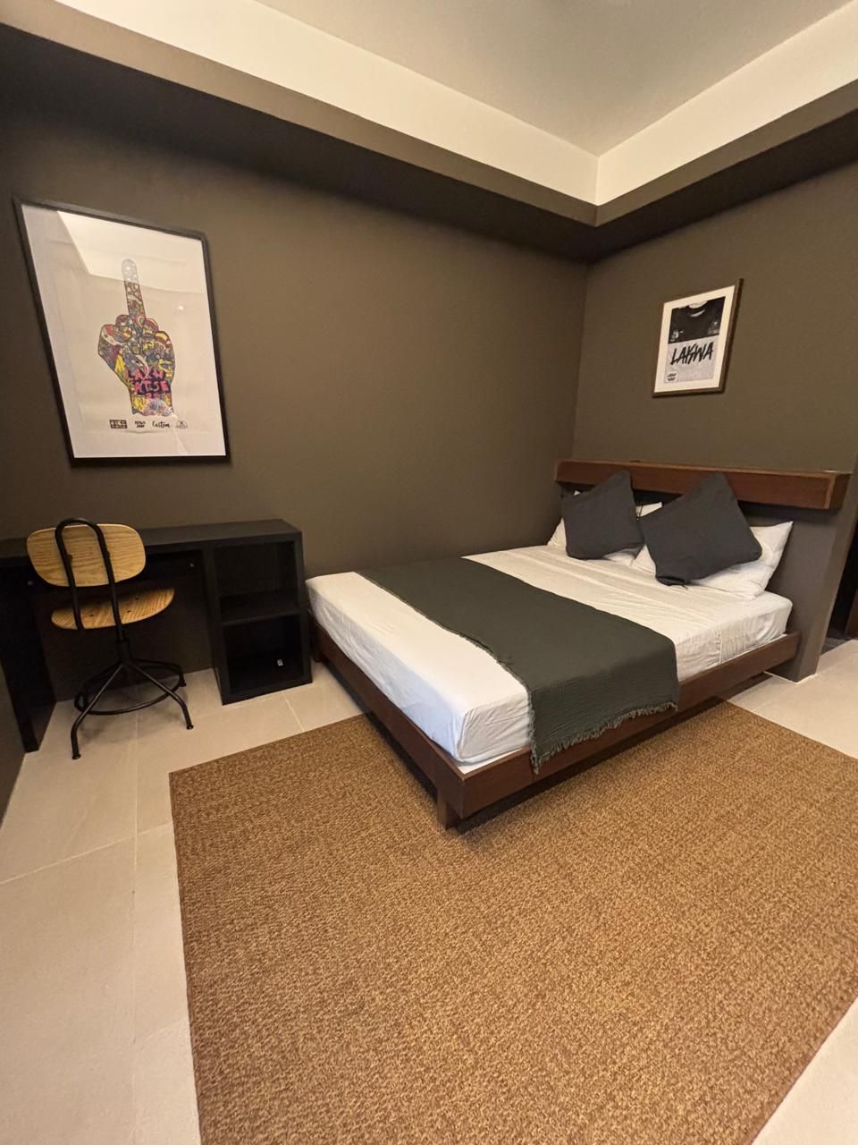 A bedroom with a bed, a desk, and a chair.
