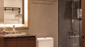 A modern bathroom with a toilet, sink, and shower area.