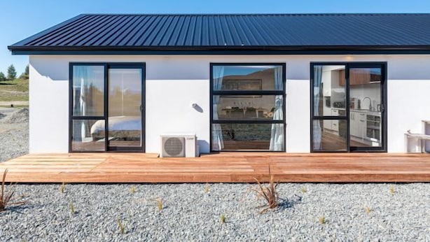 A modern two-story building with large glass doors and windows, a flat roof, and a wooden deck in front. - StarRain Tekapo (Lake Tekapo)