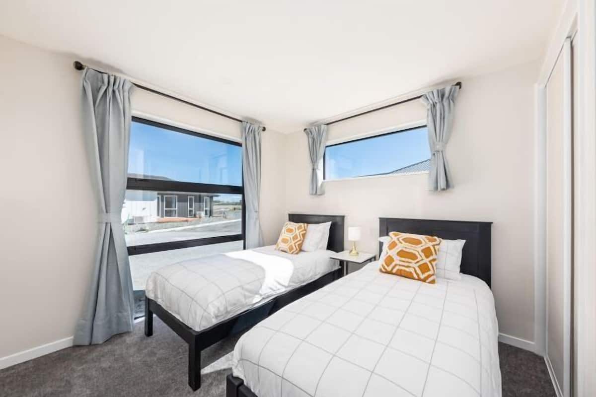 Habitación de hotel con dos camas, una ventana y vistas al exterior.