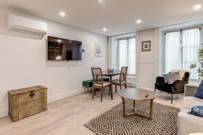 Appartement Deluxe, patio | Coin séjour | Télévision à écran plat de 55 pouces avec chaînes par câble, télévision