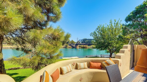 Zona relax all'aperto con vista su un fiume e un ponte.