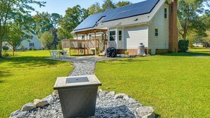 A house with a solar panel roof, a covered porch, and a stone planter in the foreground. - 15 Mi to Raleigh: Dog-Friendly Home w/ Fire Pit! (Fuquay-Varina)