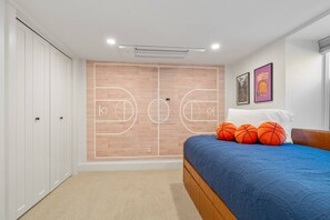 A bedroom with a basketball court design on the wall, a bed with blue bedding, and a basketball-themed poster. - Charming South Hill Craftsman Retreat near downtown—4BR, Smart TVs & Courtyard (Spokane)