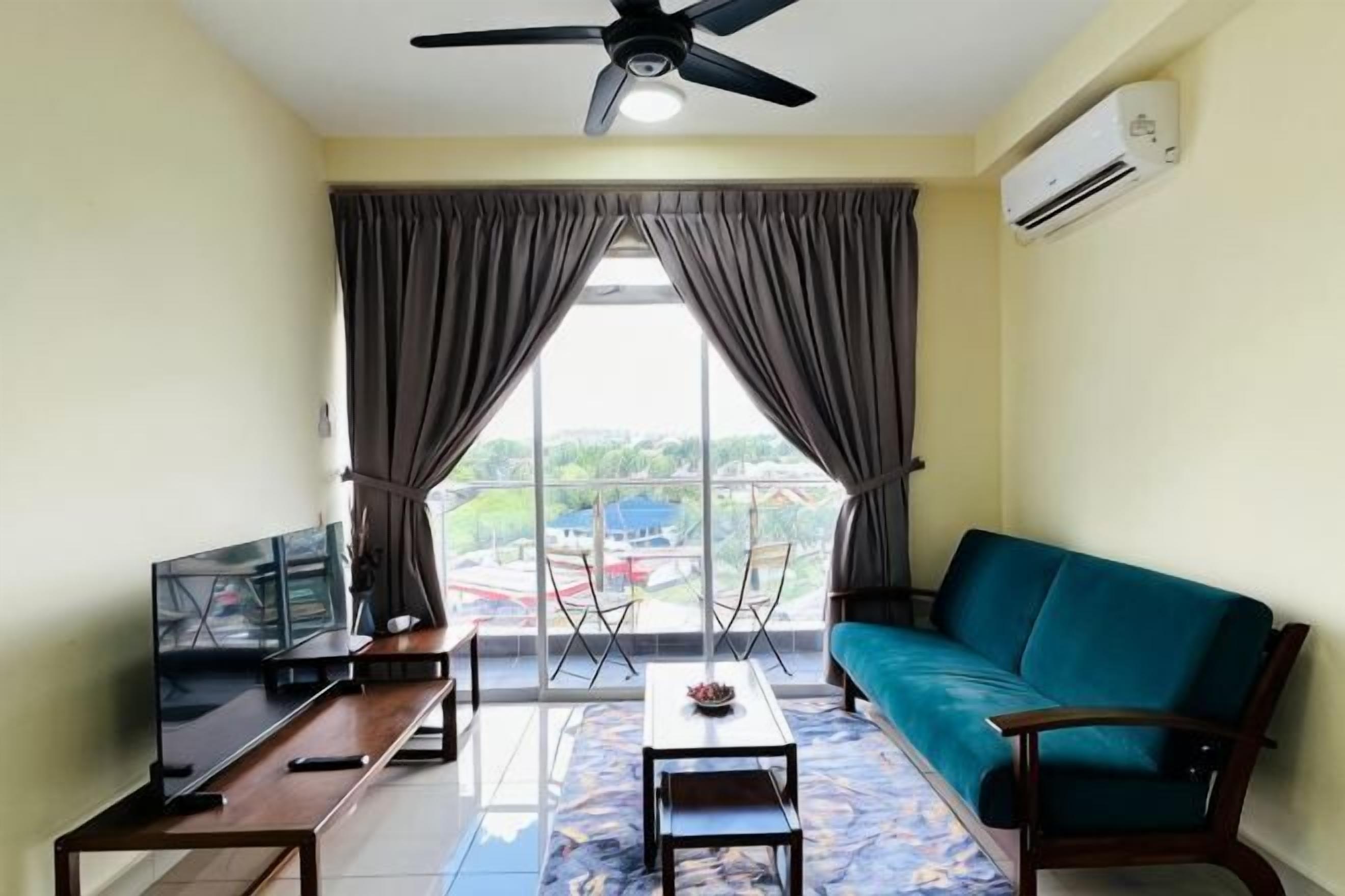 A living room with a sofa, a coffee table, a TV, and a ceiling fan.