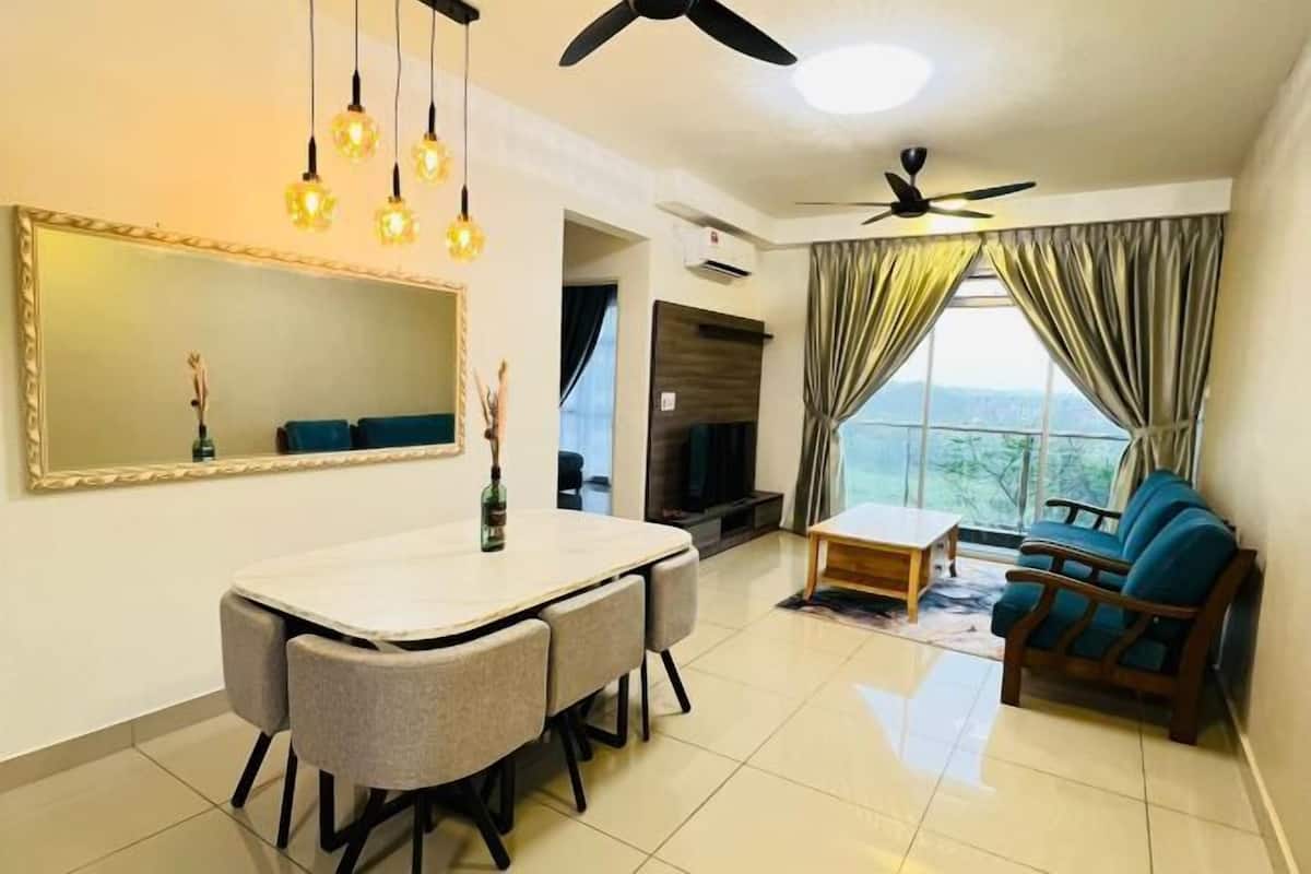 A living room with a dining table, chairs, a sofa, a TV, and a ceiling fan.
