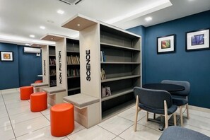 A modern library with bookshelves, seating, and a blue wall. - KULAI IOI Mall D'Putra Near JPO Senai Airport (Kulai)