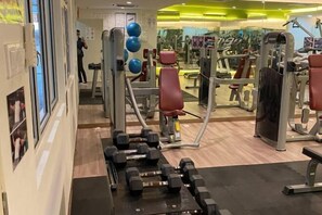 A gym with exercise equipment, mirrors, and a wall with framed pictures. - KULAI IOI Mall D'Putra Near JPO Senai Airport (Kulai)