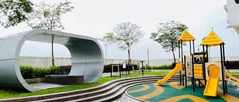 A playground with a curved structure and a slide.