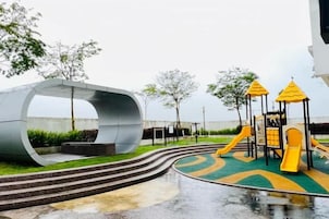 Un parque infantil con una estructura curva y un tobogán.