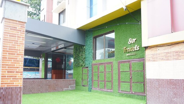 A building with a green wall and a sign that reads "Sur Travels." - SVR Hotel Sai Samrat (Rahata)
