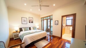A bedroom with a bed, bedside table, lamp, and a ceiling fan. - Cozy Home with fireplace 5mins to beach (Glenelg)