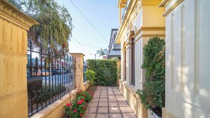 A narrow alleyway with a paved path, bordered by a yellow building on one side and a white building on the other. - Cozy Home with fireplace 5mins to beach (Glenelg)