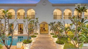 A building with a central entrance, multiple arches, and a pool area.