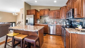 A modern kitchen with wooden cabinets, stainless steel appliances, and a granite countertop. - Pleasure Point - Waterfront house w/Dock off Bagnell Dam Strip (Lake Ozark)