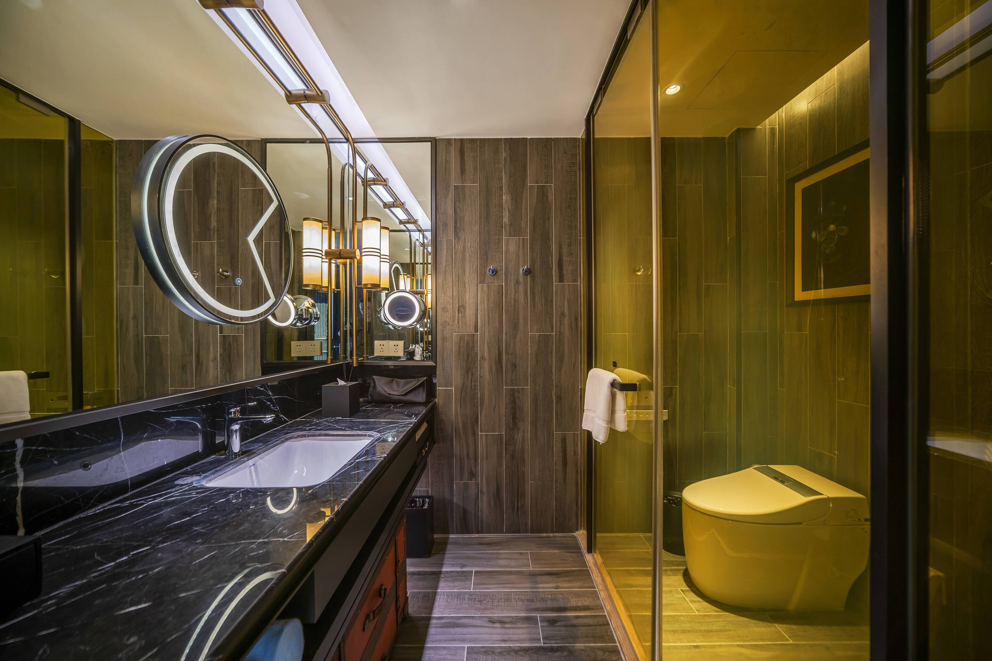 Ein modernes Badezimmer mit einem großen Spiegel, zwei Waschbecken, einer Toilette und einer Duschkabine.