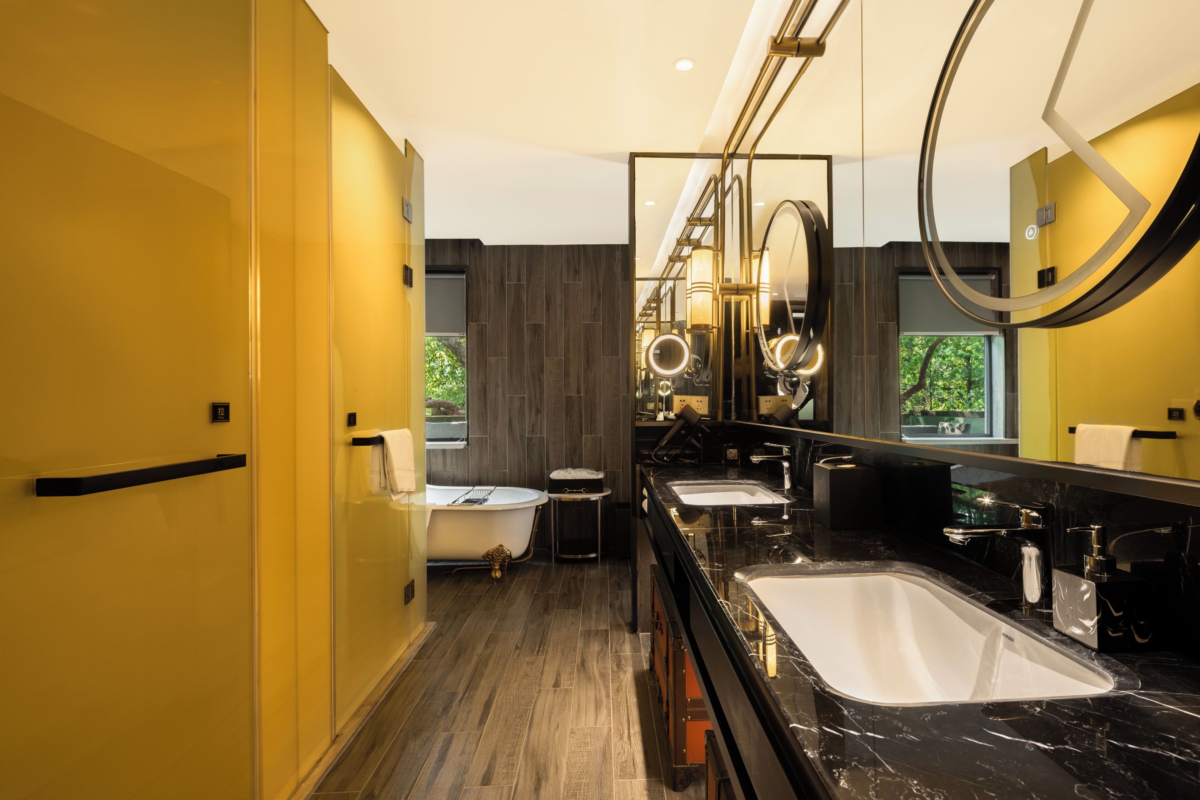 Ein modernes Badezimmer mit einem großen Spiegel, zwei Waschbecken, einer Badewanne und einem Waschtisch mit Spiegel.