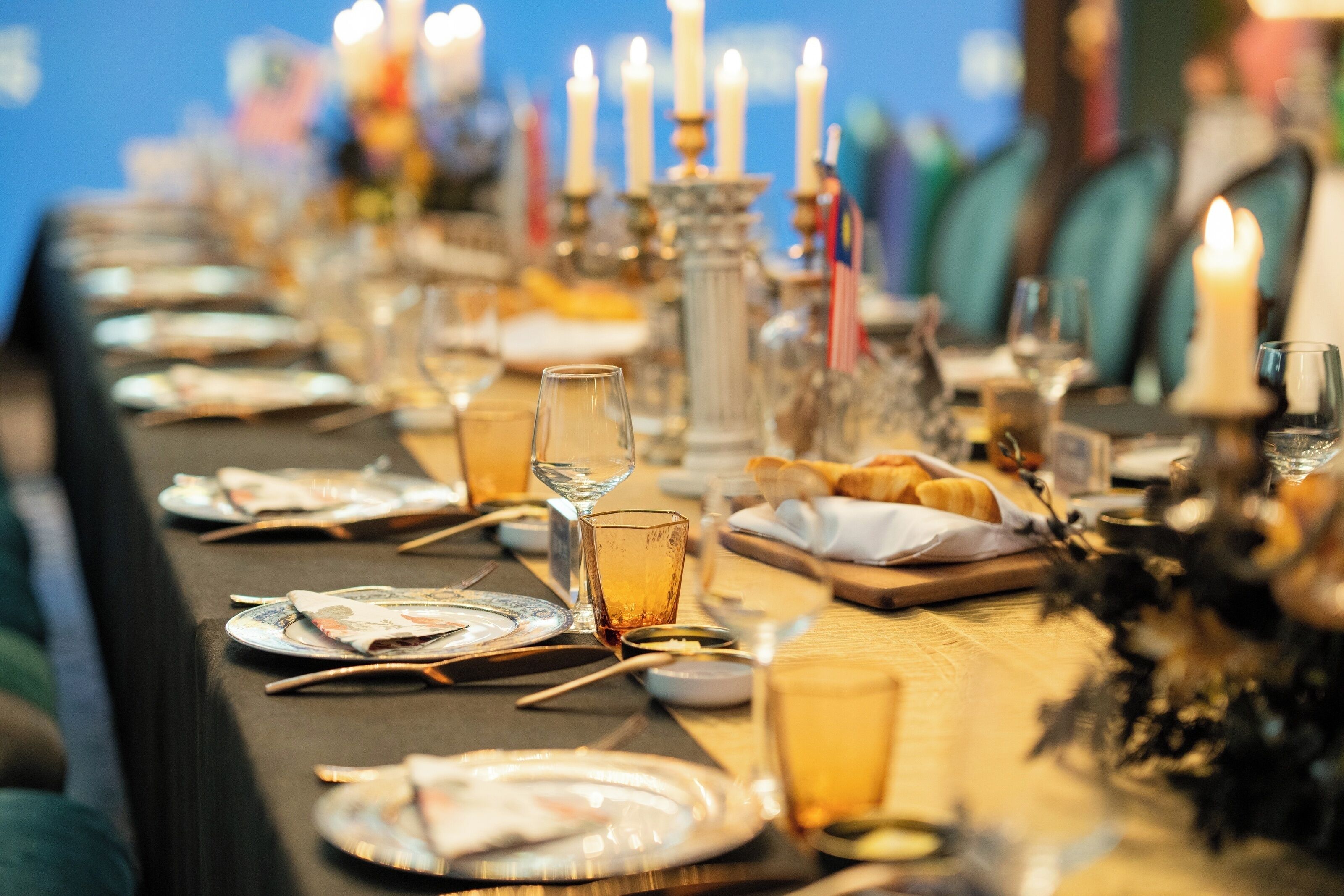 A table set for a meal with plates, glasses, and candles.