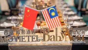 A sign with flags of China and Malaysia and the text "MOVIETEL" and "BabNesti".