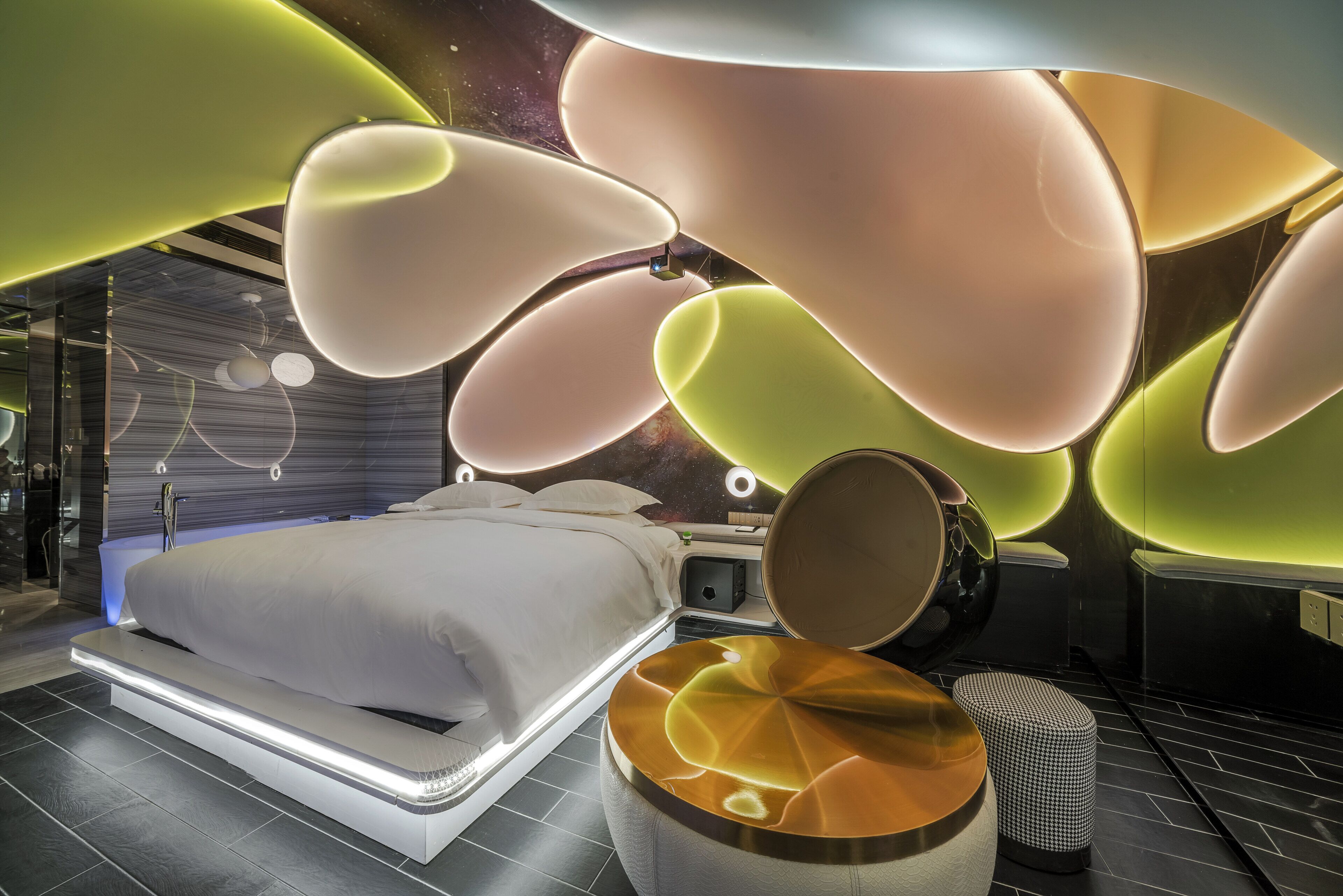 Un dormitorio moderno con una cama grande, mesitas de noche y un diseño de techo original.