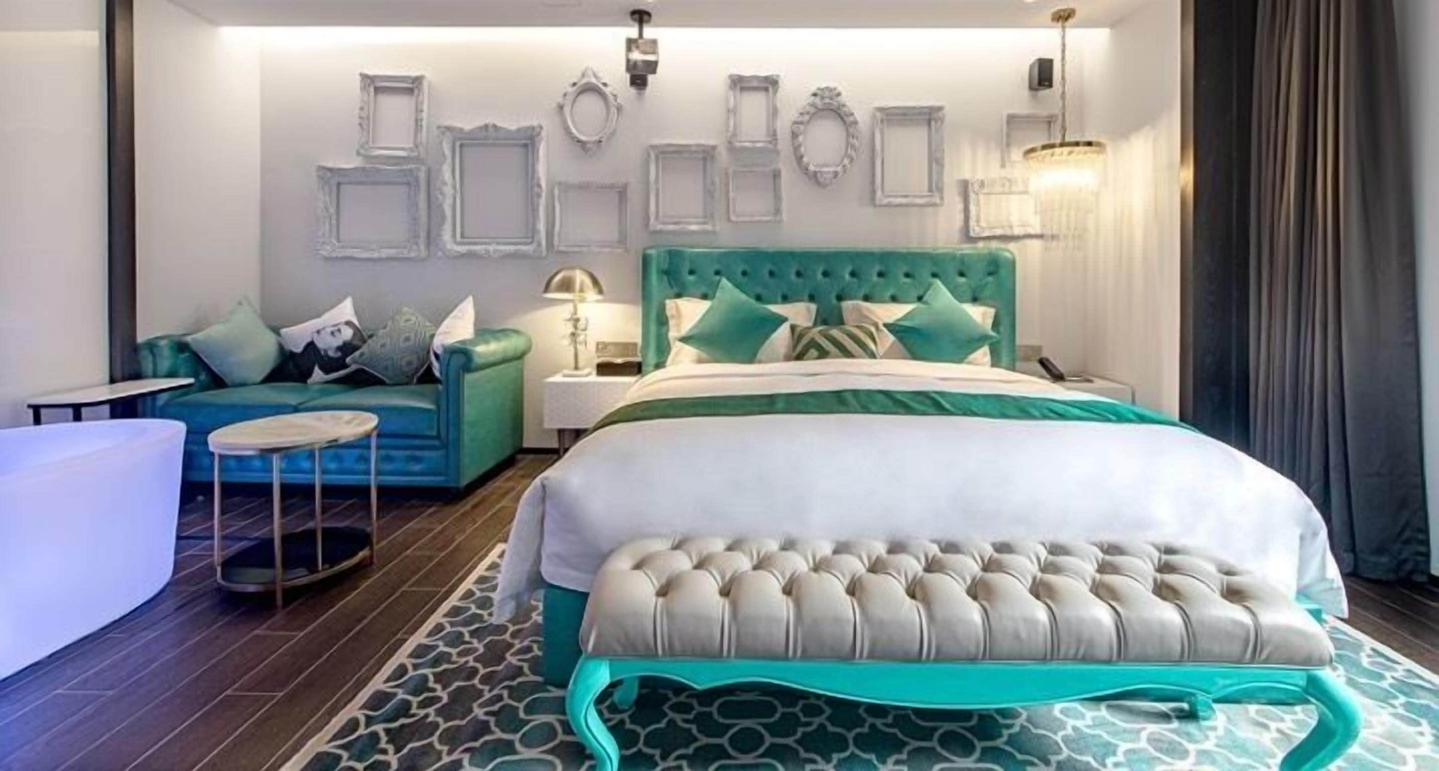 Une chambre moderne avec un grand lit, un canapé et une petite table ronde.