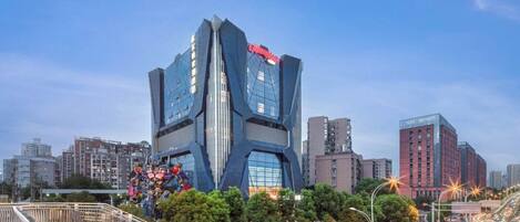 A modern building with a unique angular design, featuring a prominent sign on the top.
