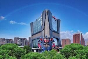 A modern building with a unique architectural design, featuring a central vertical element and multiple wings.
