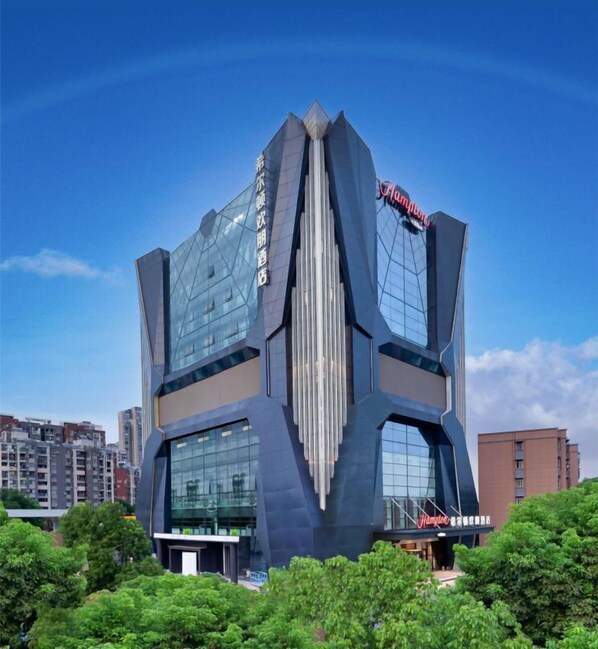 Un edificio moderno con un diseño geométrico distintivo, que muestra un letrero destacado de 'Hampton' en la parte superior.
