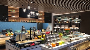 Un buffet moderne proposant une grande variété de plats et un espace de libre-service pour les boissons.