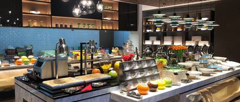 Un buffet moderne proposant une grande variété de plats et un espace de libre-service pour les boissons.