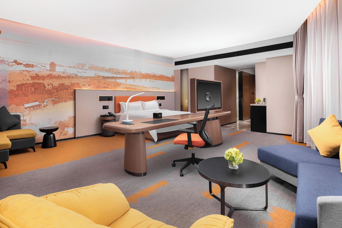 Una habitación de hotel moderna con cama, escritorio y zona de estar.