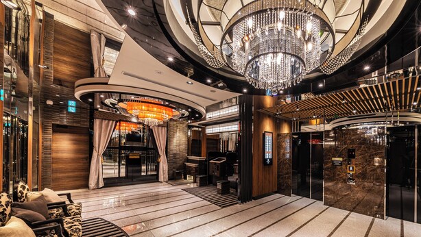 A spacious lobby with a grand chandelier, a reception desk, and a modern elevator. - APA Hotel Akabane Iwabuchi Ekimae (Tokyo)