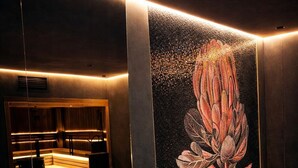 A spa area with wooden steps leading to a hot tub, a wall with a lotus flower mural, and a wooden bench. - Monte Pine Chalet 1 (Kovacka Dolina)