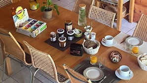 A wooden dining area with a table set for breakfast, including bread, butter, jam, and a coffee pot. - La Caminade (Bourg-de-Bigorre)