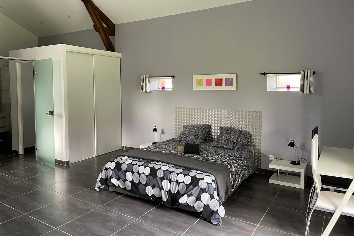 Ein Schlafzimmer mit einem Bett, einem Schreibtisch, einem Stuhl und einem Kleiderschrank.