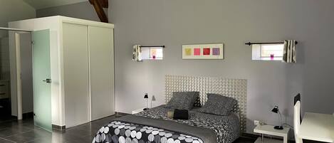 A bedroom with a bed, a desk, a chair, and a wardrobe.
