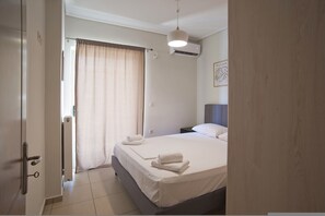 A hotel room with a bed, a nightstand, a lamp, and a window with curtains. - Filoxenia With 1 Bedrooms and 1 Bathrooms (Chaidari)
