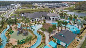 A resort with a swimming pool, a water slide, and a boat ramp.