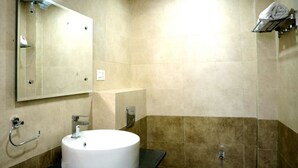 Ein Badezimmer mit einem runden Waschbecken, einer Toilette und einem Spiegel.
