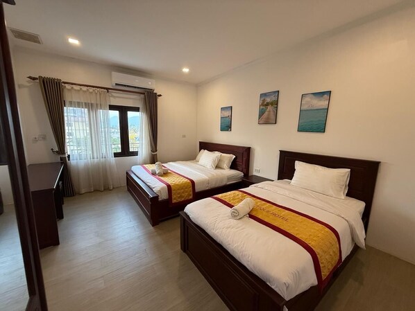 A hotel room with two beds, a desk, and a window with curtains. - A P S Boutique Hotel (Vang Vieng)