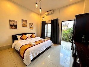 A hotel room with a large bed, a balcony, and a TV. - A P S Boutique Hotel (Vang Vieng)
