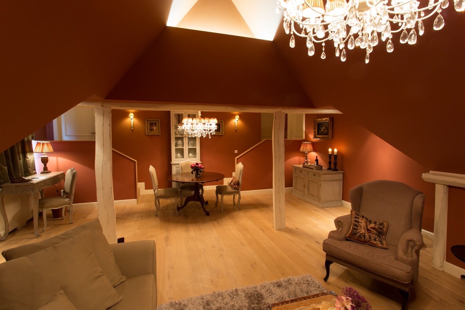 A spacious loft with a dining area, a chandelier, and a cozy seating arrangement.