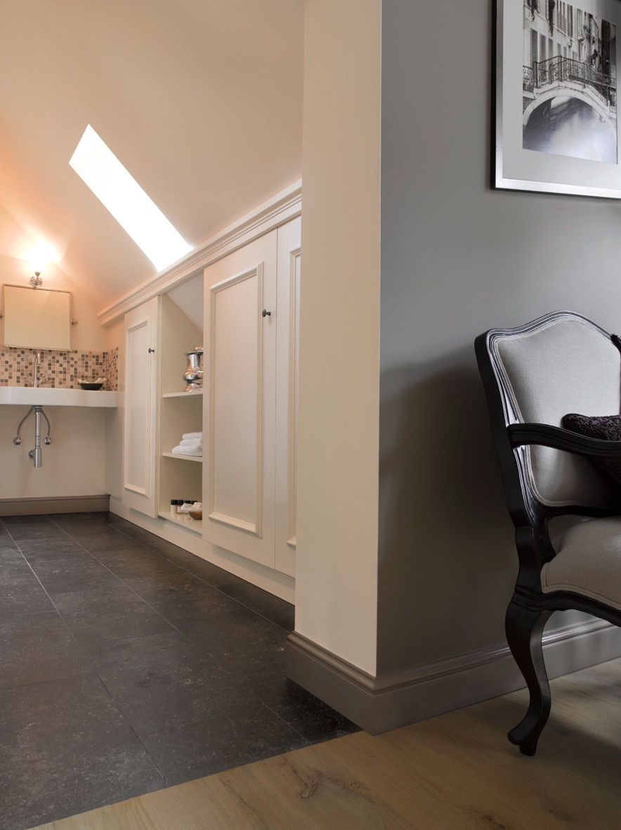 Une salle de bain avec un meuble-lavabo blanc, un miroir, un porte-serviettes et une étagère contenant des articles de toilette.