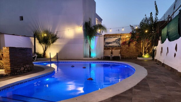 A swimming pool with a curved edge, surrounded by a stone-tiled deck.