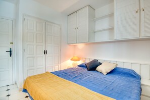 A bedroom with a bed, white wardrobe, and a nightstand with a lamp. - Magnificent apartment with pool 2 minutes from Pals beach (Pals)