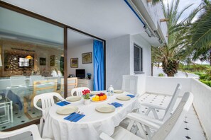 An outdoor dining area with a white table set for four, surrounded by white chairs. - Magnificent apartment with pool 2 minutes from Pals beach (Pals)