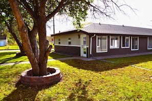 A single-story building with a flat roof, a brick foundation, and a small front porch.