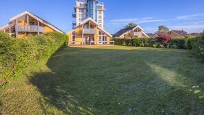 A modern hotel with a central tower, multiple balconies, and a well-maintained lawn. - Exclusive skandinavisches, Rechlin (Rechlin)